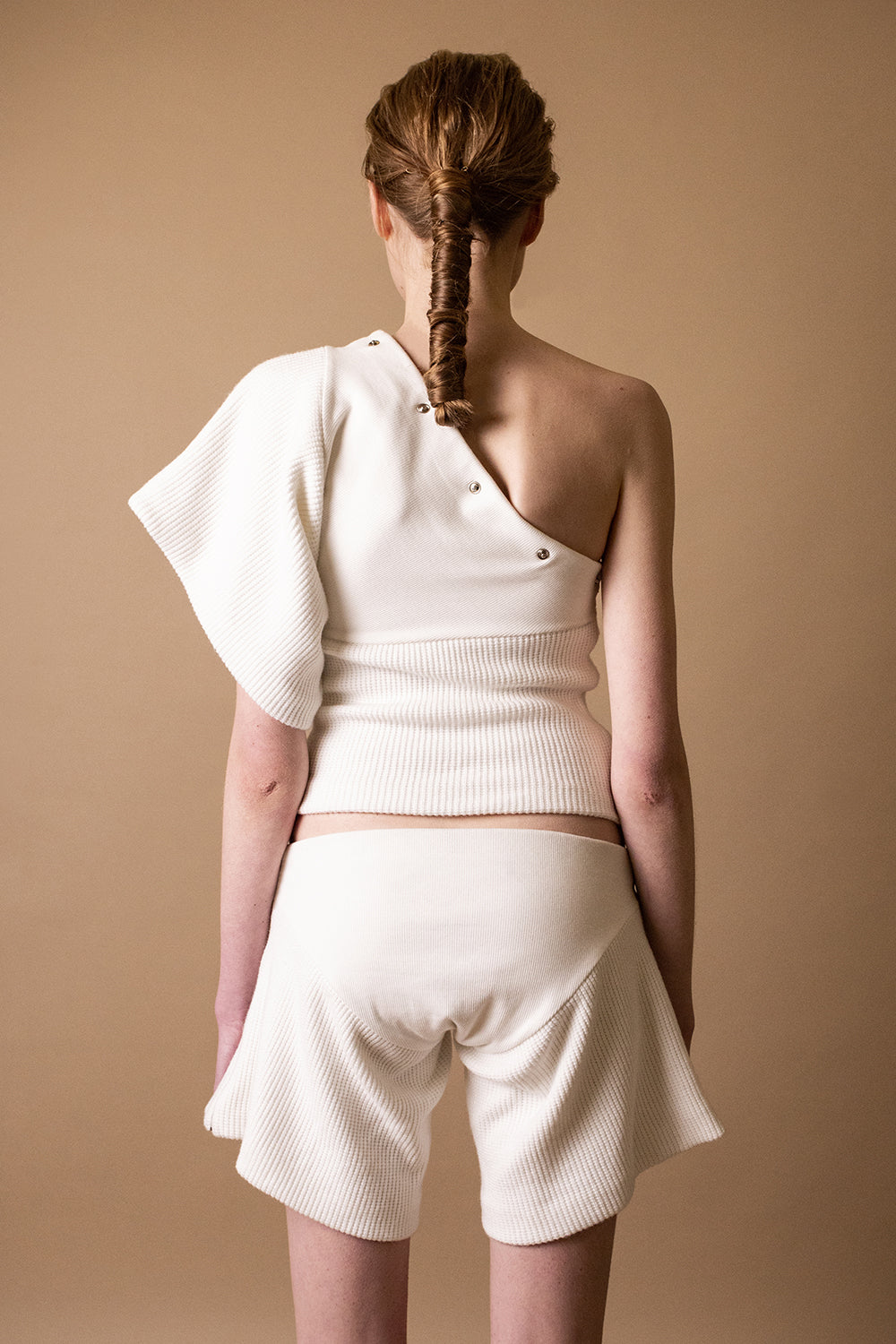 DZHUS Duplicate in white as a one-shoulder shirt and shorts back look